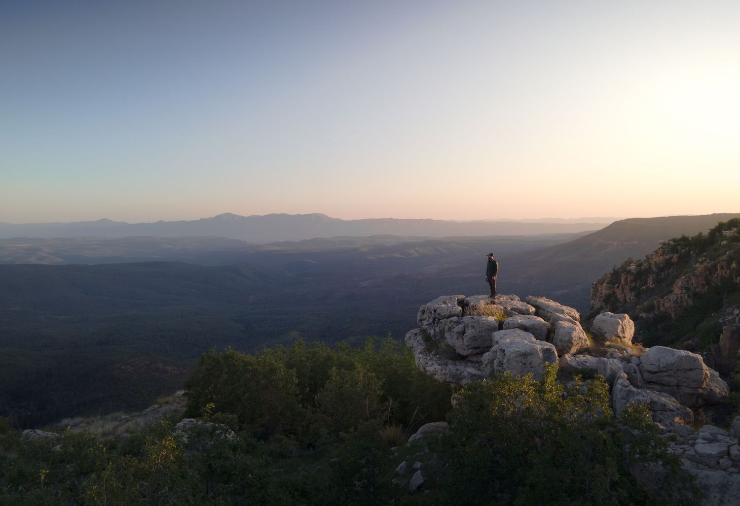 Jake Shebitz stands on top of the Mogollon Rim in Arizona during sunset.