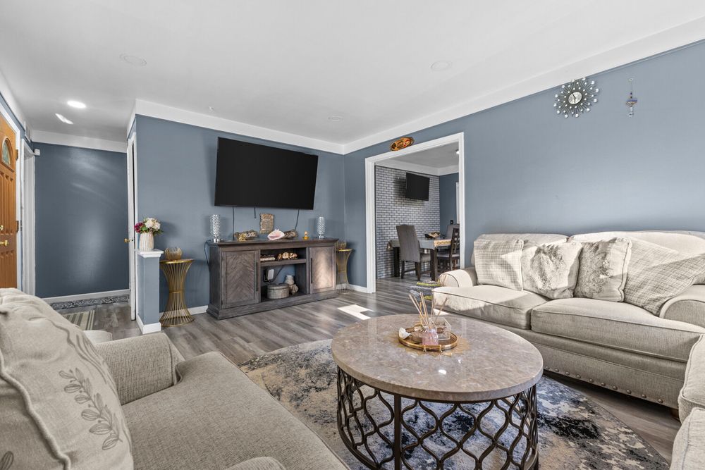 Living room with blue accent walls and large picture window in Dearborn Michigan ranch home
