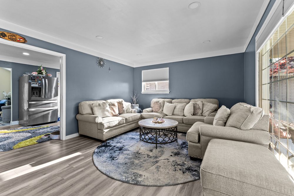 Living room with blue accent walls and large picture window in Dearborn Michigan ranch home