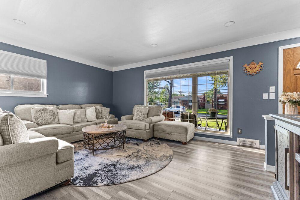 Living room with blue accent walls and large picture window in Dearborn Michigan ranch home