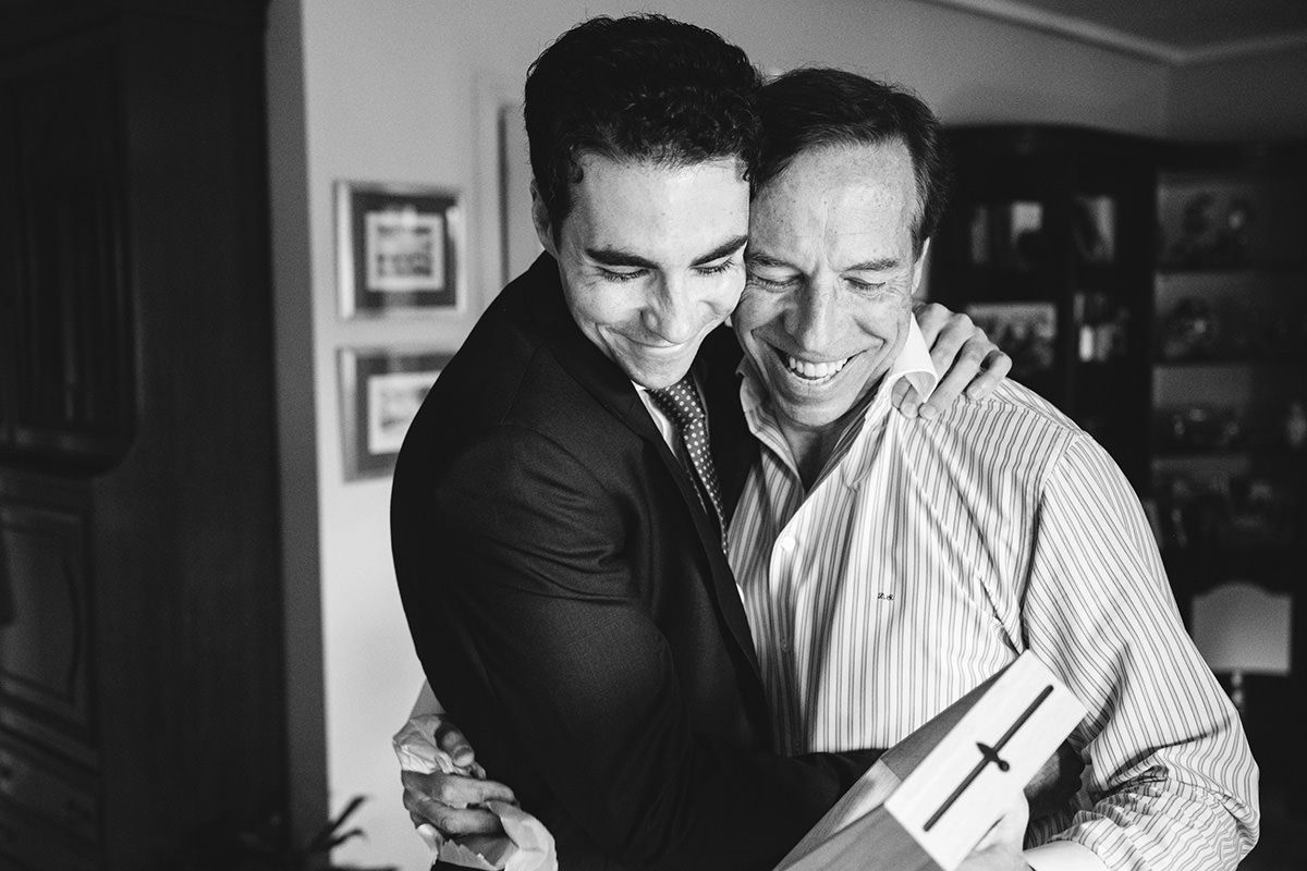 Padre y novio abrazándose emocionados durante los preparativos de una boda en Asturias
