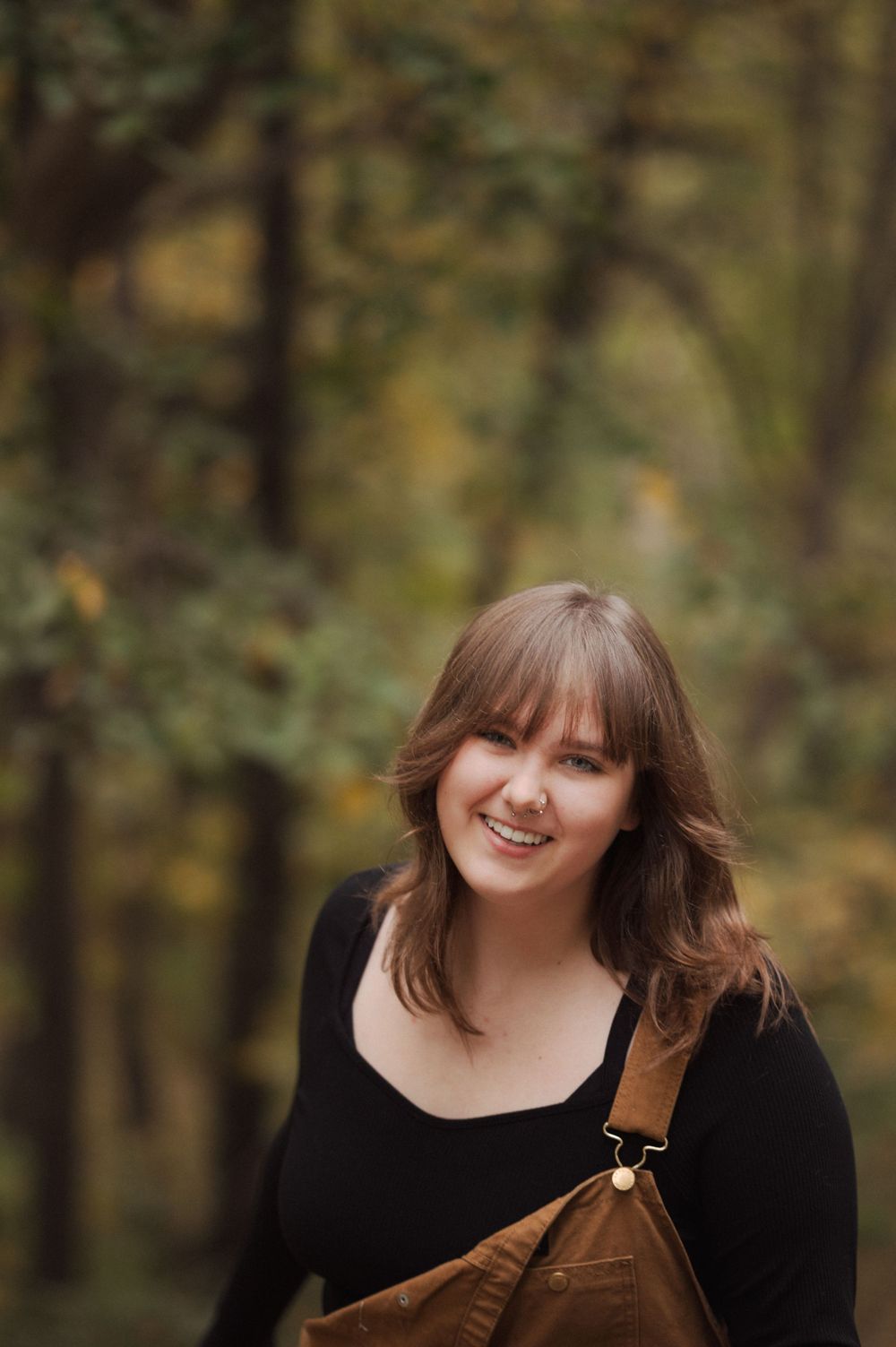 Outdoor senior girl photos with dark green hues, soft natural light and a timeless warm editing style.