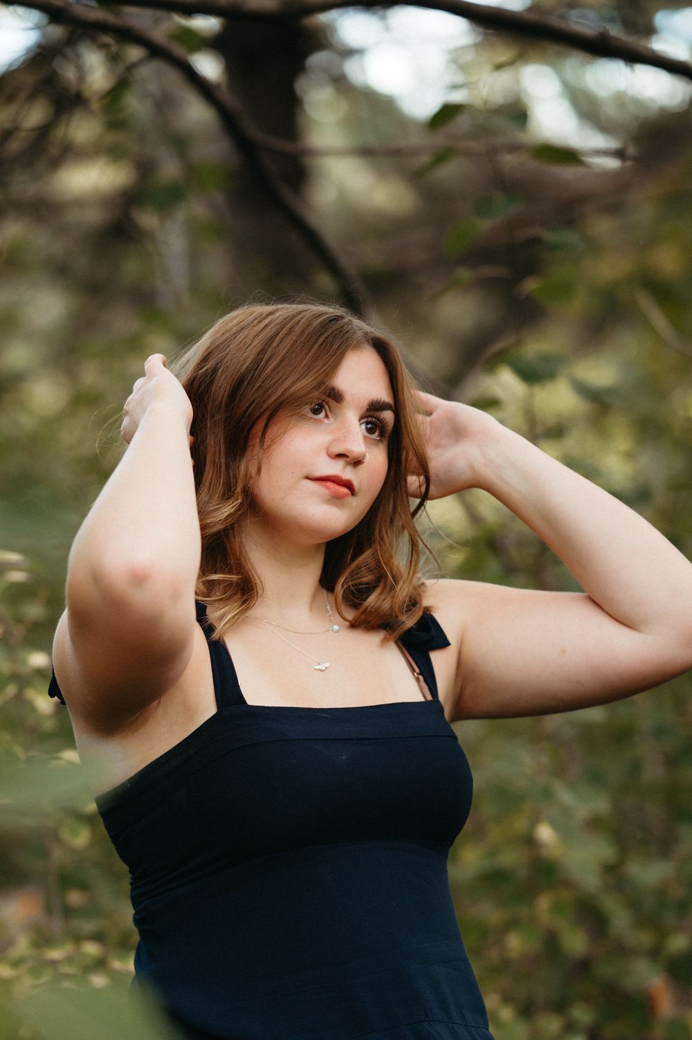 Outdoor senior photography with deep green tones, warm timeless edits and a film-inspired portrait style.