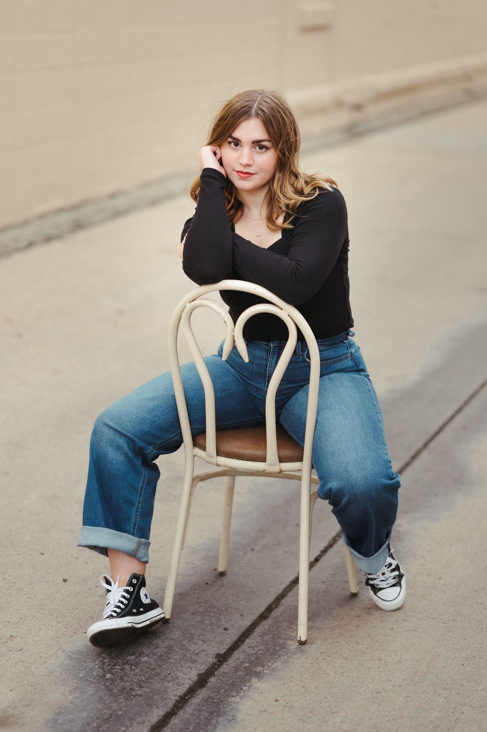 Senior girl in a urban alley setting with concrete, soft warmth and clean timeless edits.