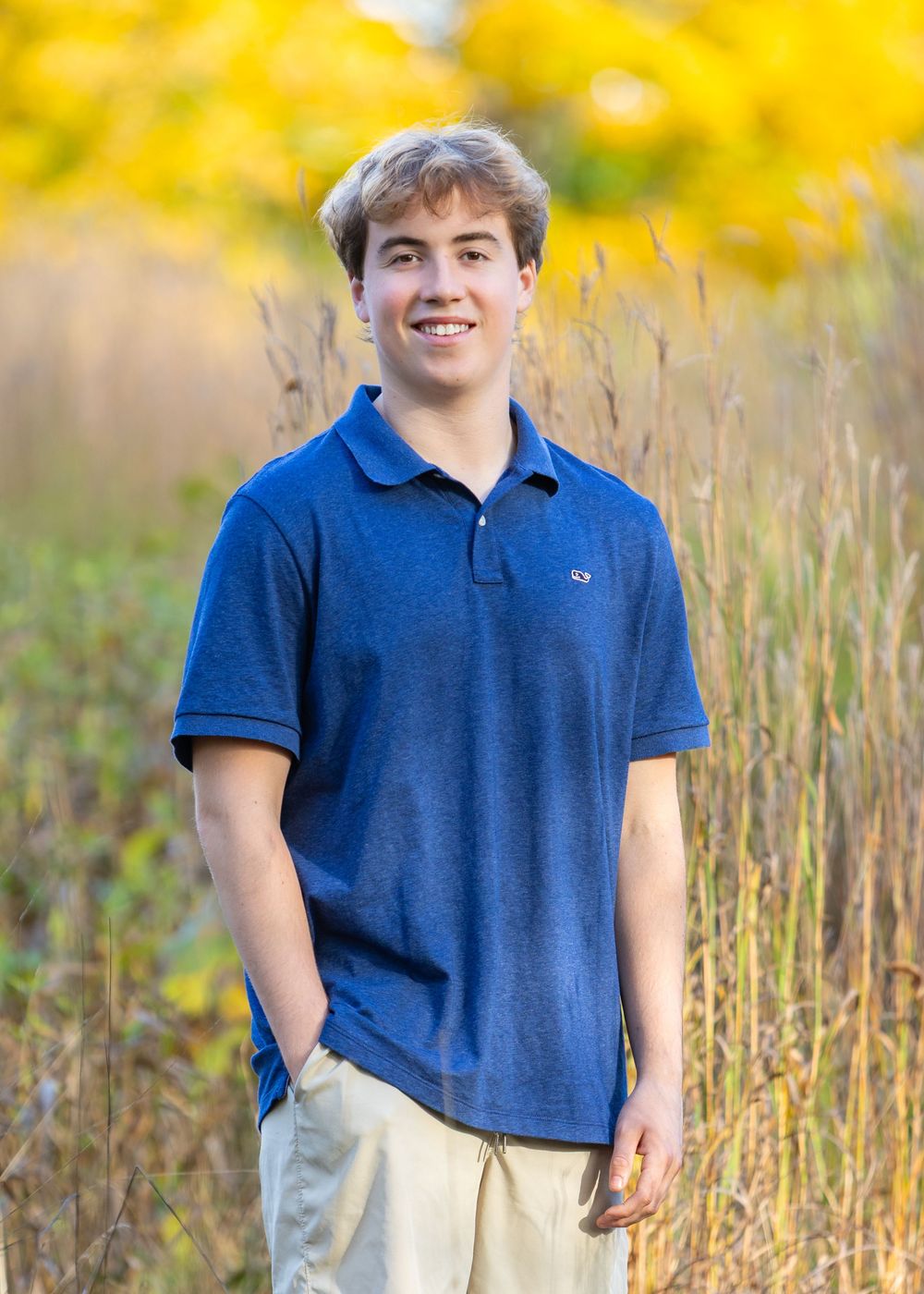High school senior in a meadow by North Bridge Concord, MA for yearbook portrait session at sunset golden hour. High School photos