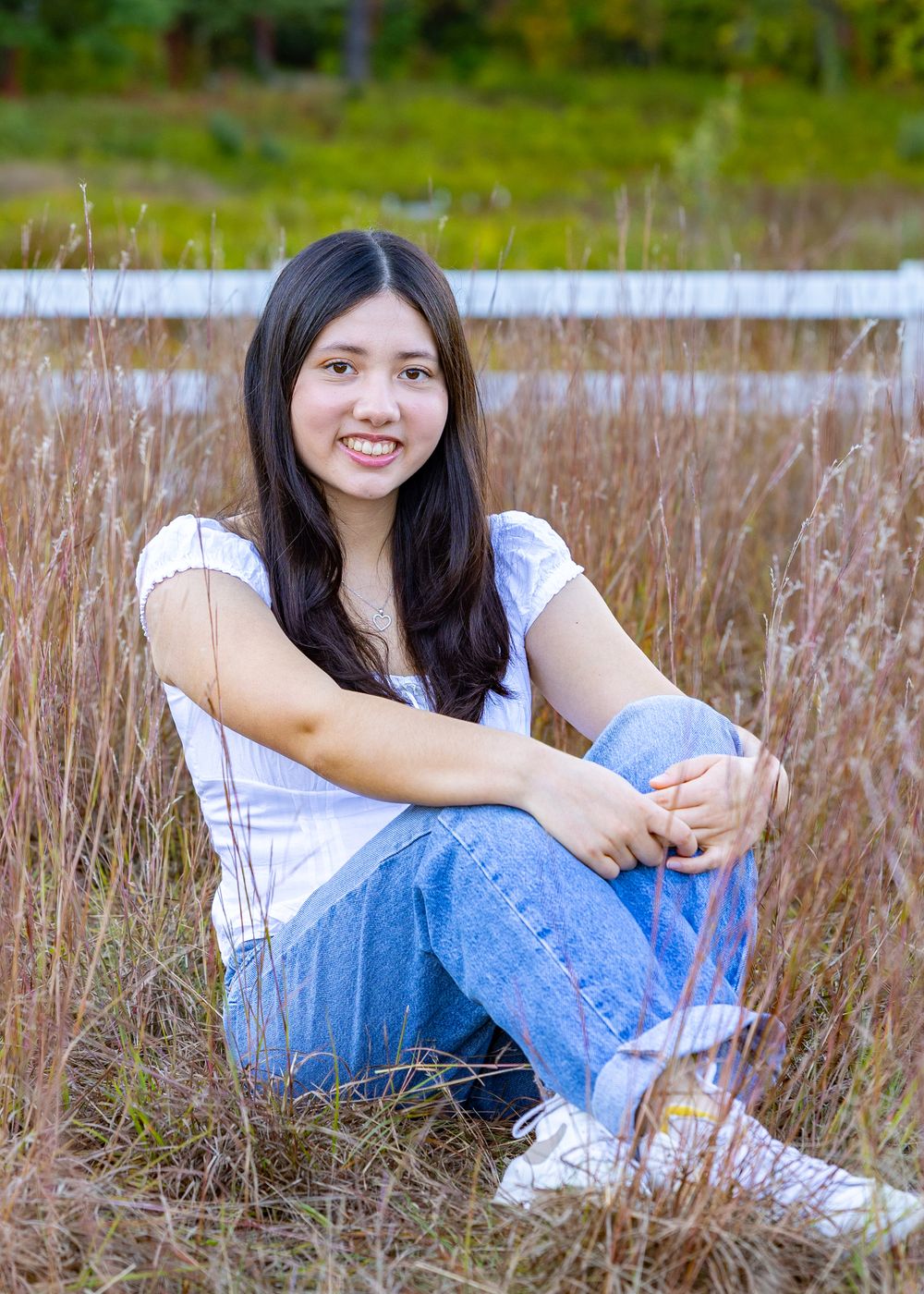 A Lincoln Sudbury Senior poses in a grassy field in Sudbury, MA for yearbook portrait session. High School senior photographer. Weston.