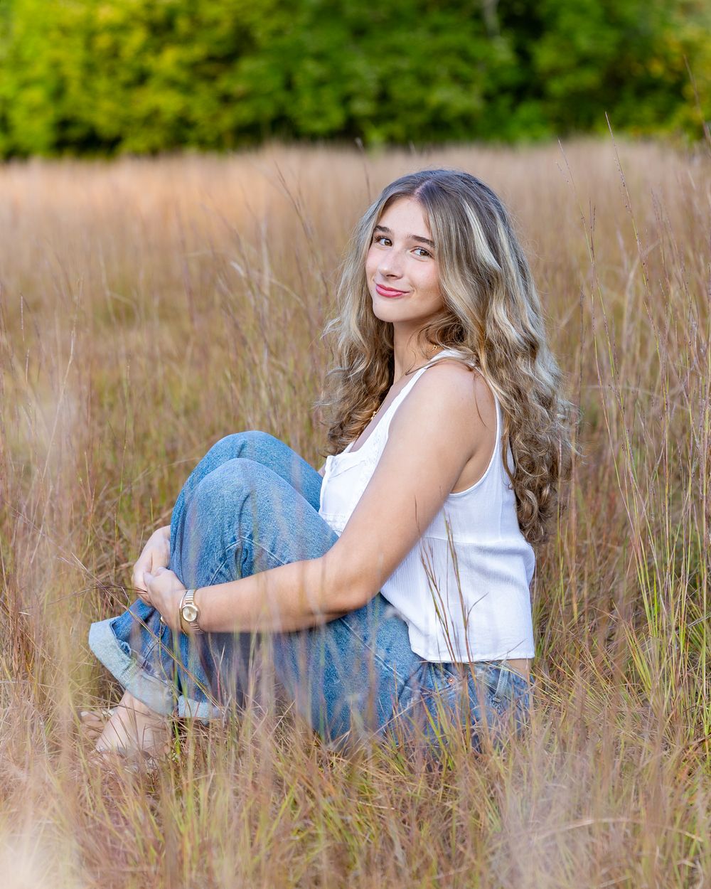A Lincoln Sudbury Senior poses in a grassy field in Sudbury, MA for yearbook portrait session. High School senior photographer. Weston.