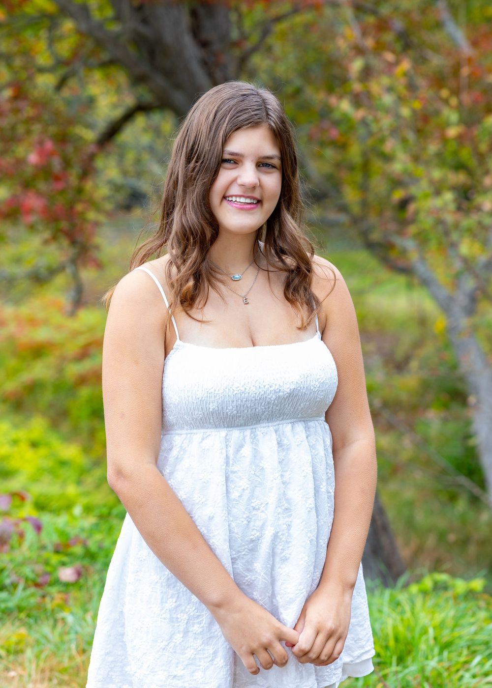 A Lincoln Sudbury Senior poses in a grassy field in Sudbury, MA for yearbook portrait session. High School senior photographer. Weston.