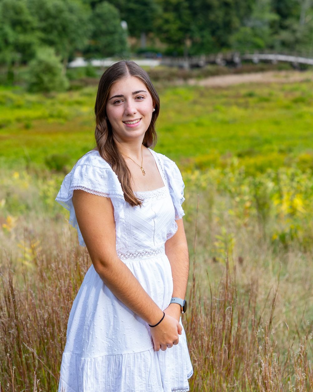 High school senior in a meadow by North Bridge Concord, MA for yearbook portrait session at sunset golden hour. High School photos