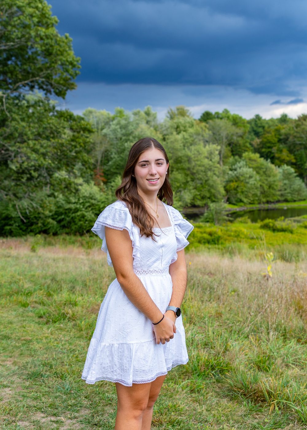High school senior in a meadow by North Bridge Concord, MA for yearbook portrait session at sunset golden hour. High School photos