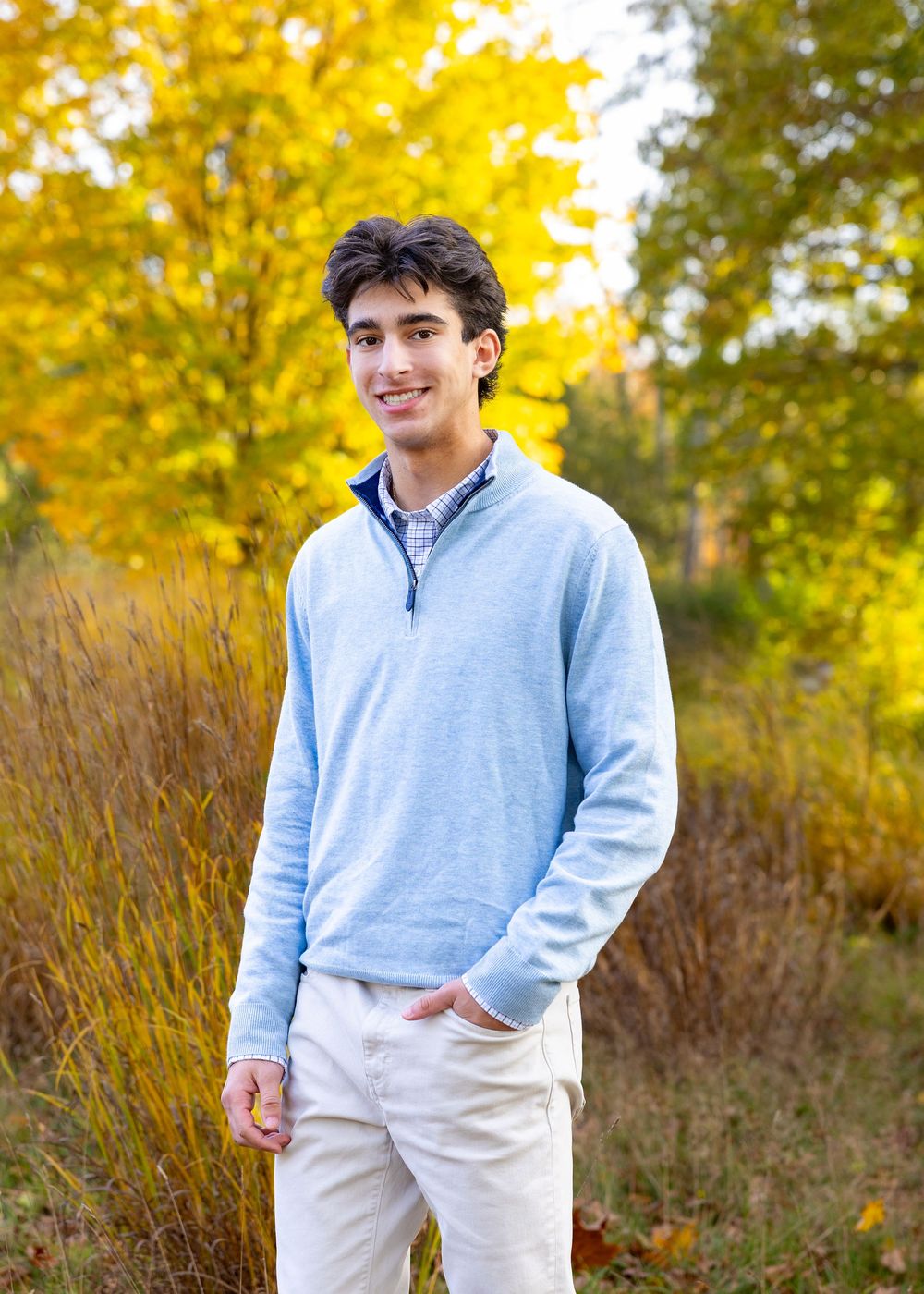 High school senior in a meadow by North Bridge Concord, MA for yearbook portrait session at sunset golden hour. High School photos