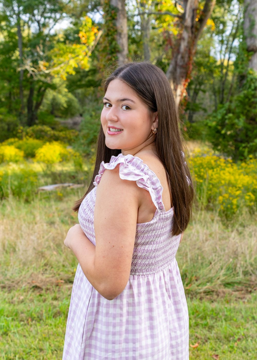 High school senior in a meadow by North Bridge Concord, MA for yearbook portrait session at sunset golden hour. High School photos
