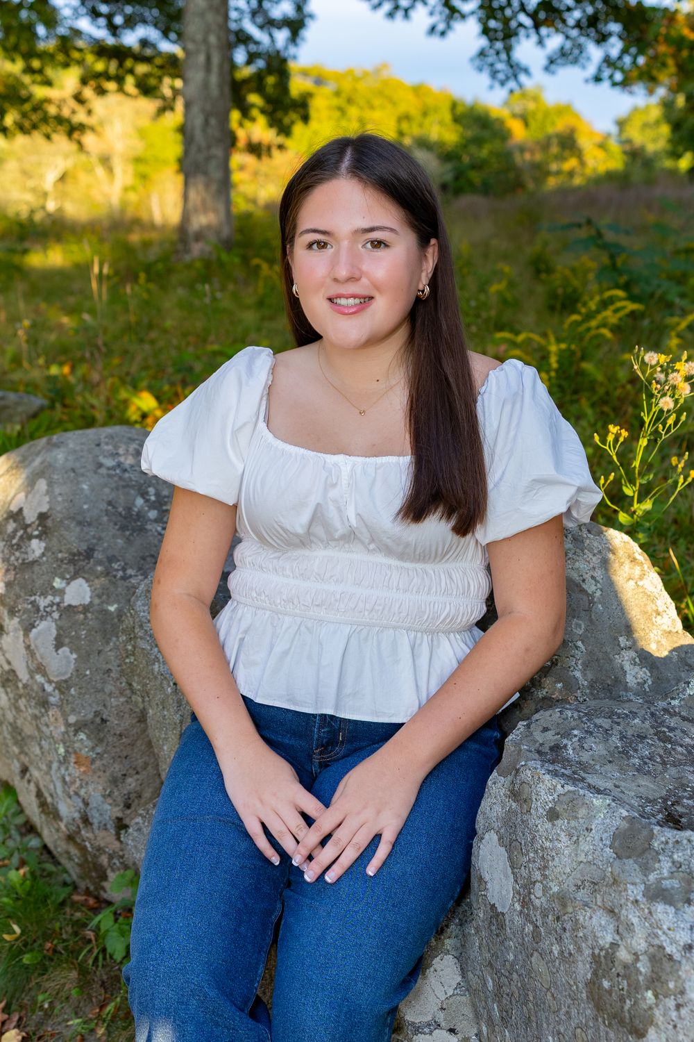 High school senior on stone wall by North Bridge Concord, MA for yearbook portrait session at sunset golden hour. High School photos