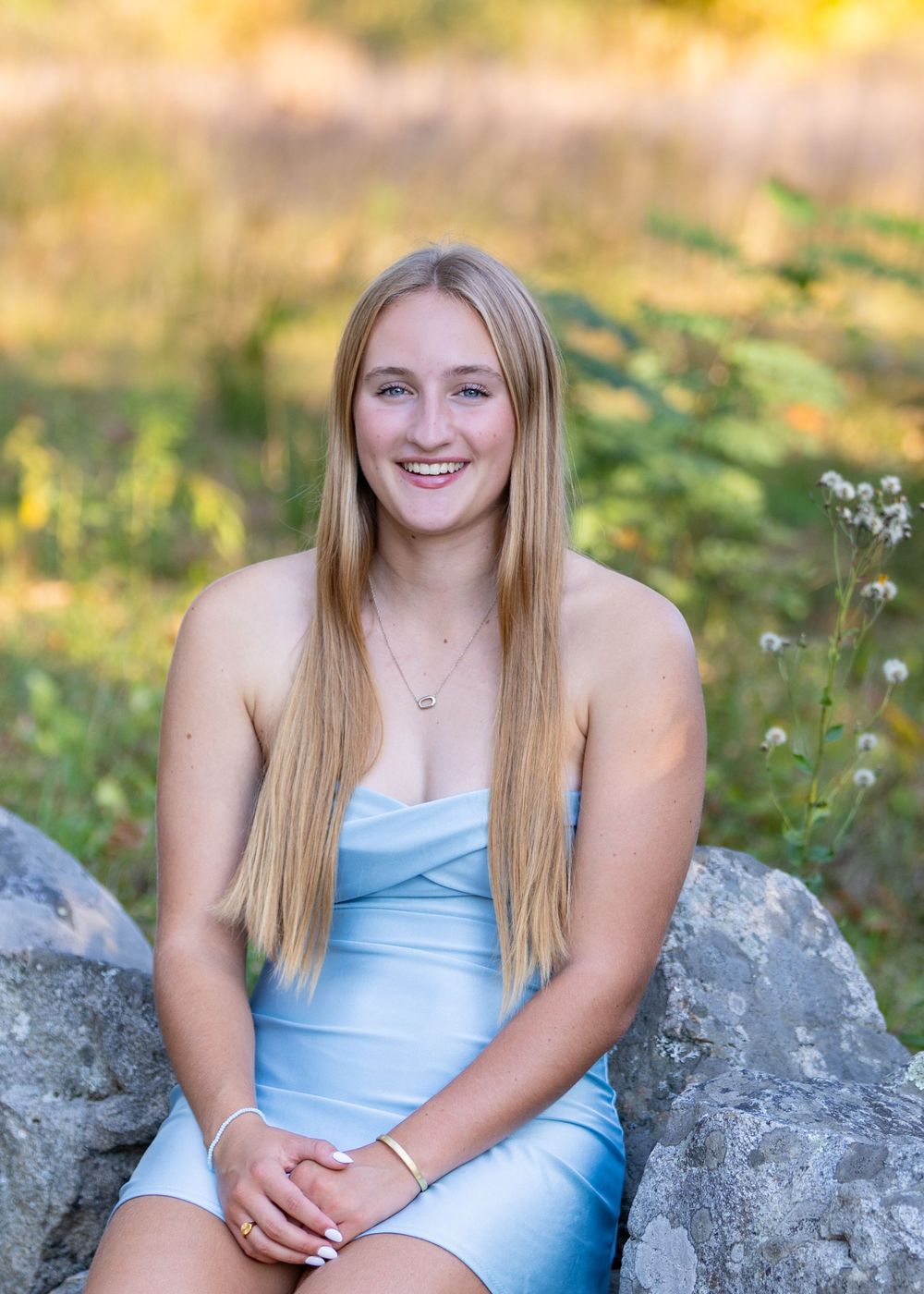 High school senior in a meadow by North Bridge Concord, MA for yearbook portrait session at sunset golden hour. High School photos