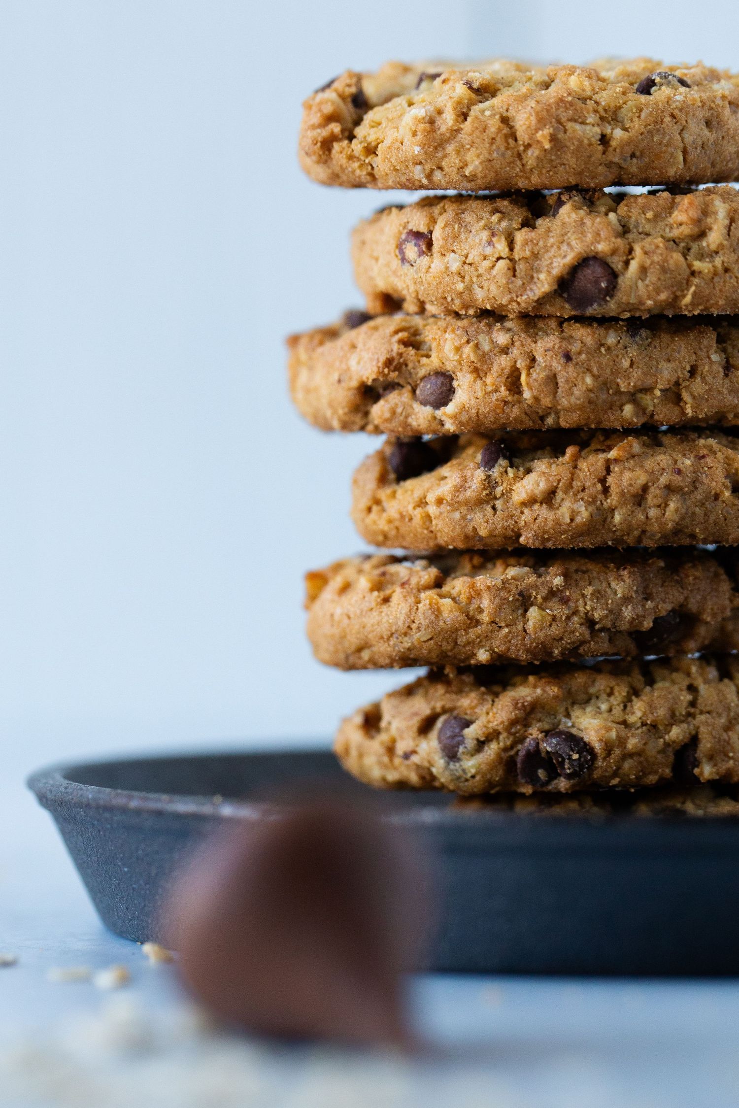 Photo of a stack of Cowboy Cookies by HEB in a cast iron skillet with a Hershey's kiss in the foreground by Bella Priscilla Photography