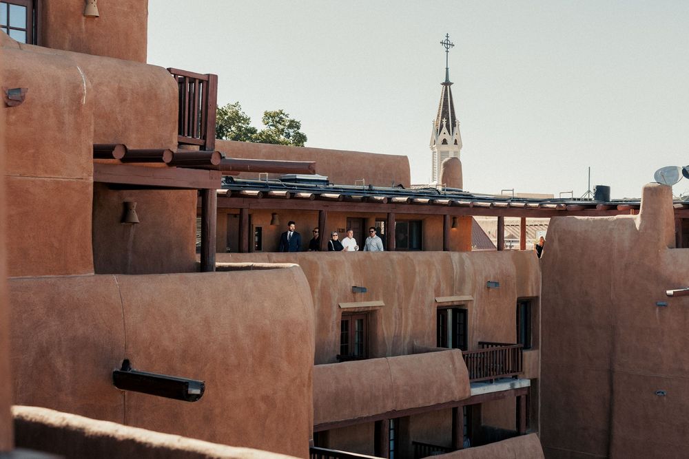 Adobe-style pueblo architecture with a church steeple rising above terracotta buildings in Santa Fe, New Mexico.