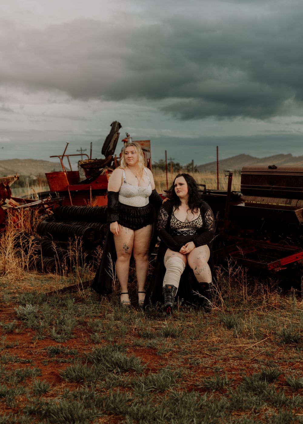 Two women pose in field for dramatic, cinematic, portrait, and modeling photos in Fort Collins, Colorado