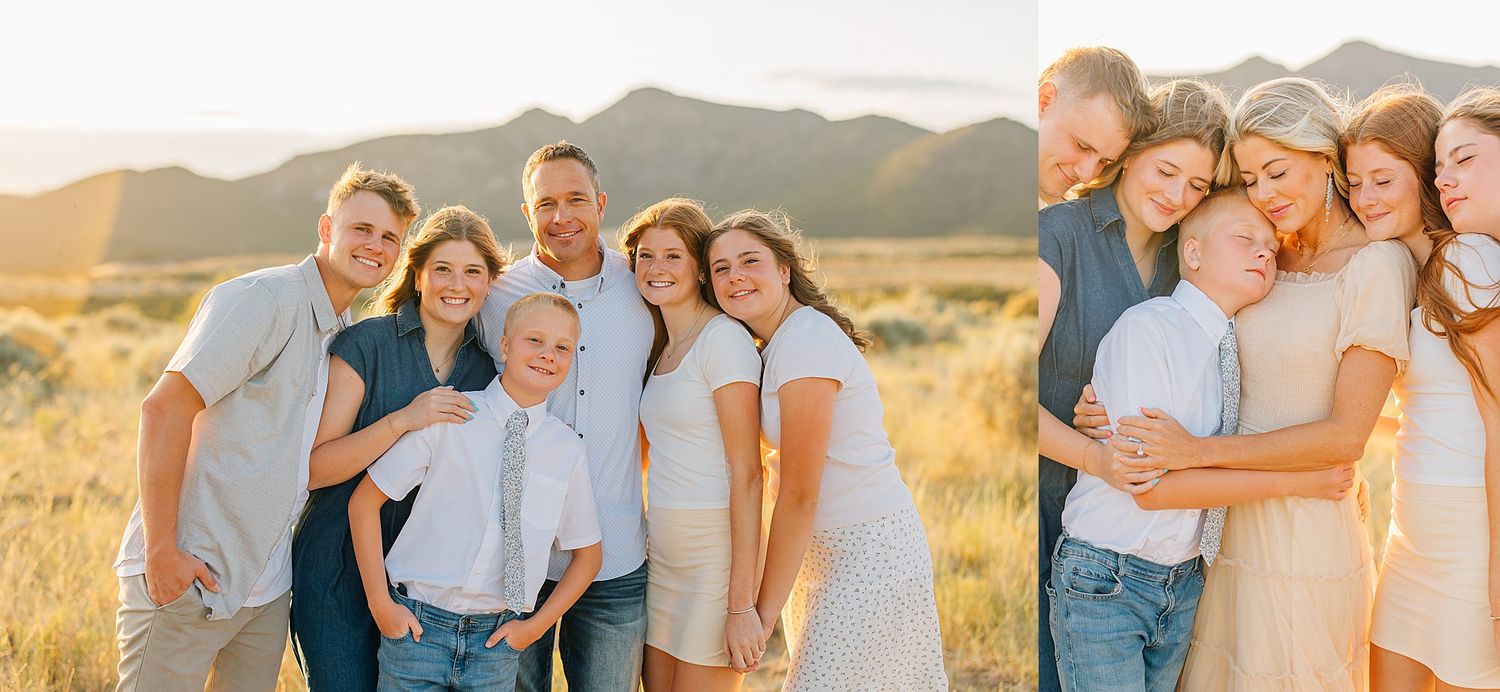 Golden hour family portrait in a field with mountain backdrop, featuring parents and children in coordinating white and blue outfits.