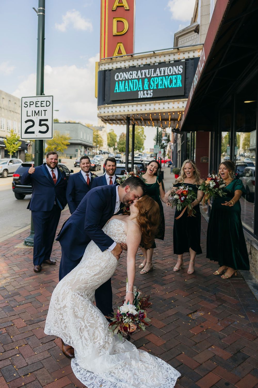 Bride and groom share a dip kiss outside Ada Theater marquee congratulating Amanda and Spencer on their wedding day in Saint Charles, IL