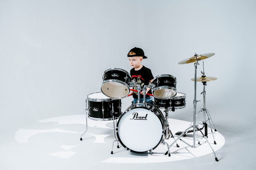 Black and white drum kit with cymbals photographed from multiple angles against a light background.