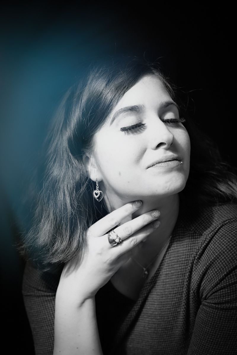 A series of moody black and white portraits showing dramatic expressions with closed eyes and hand gestures against dark background.