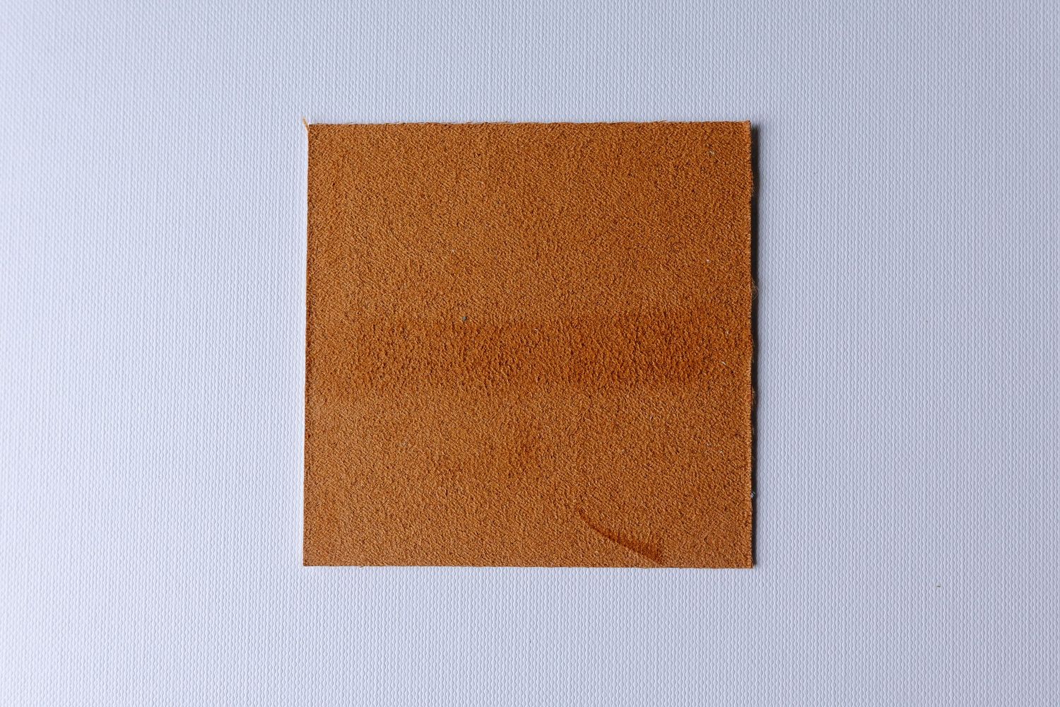 A series of brown leather or suede material swatches arranged in a row against a light gray background.