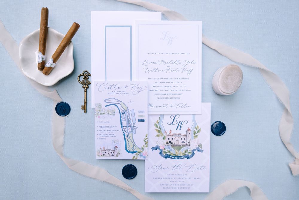 Wedding stationery flatlay with blue wax seals, silk ribbons and delicate calligraphy details.