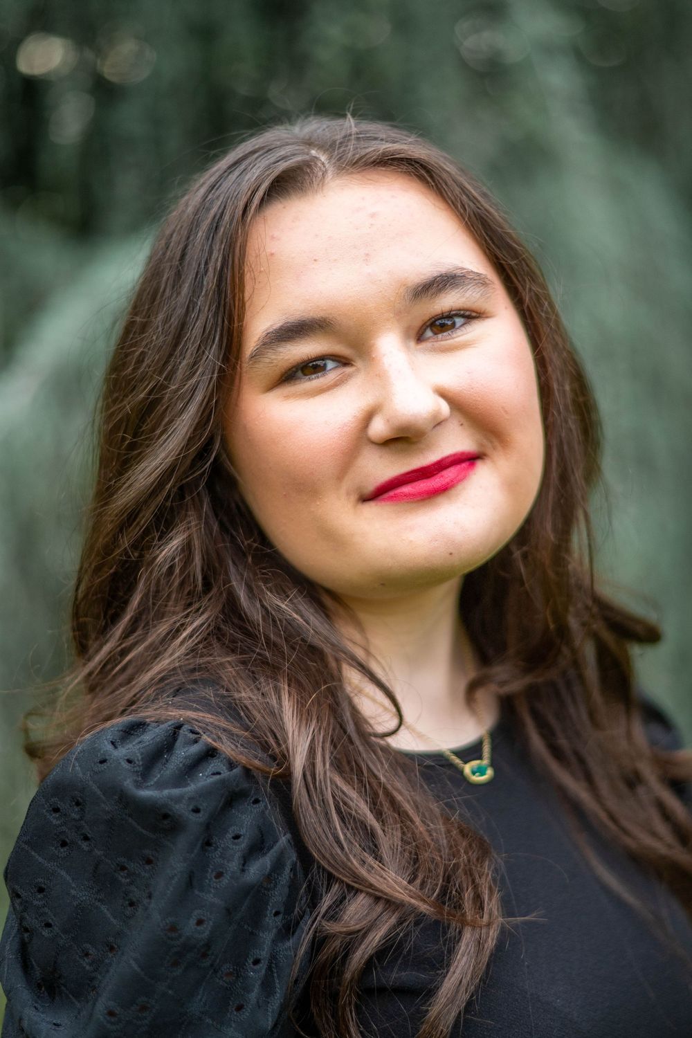 A series of five close-up portraits showing joyful expressions and red lipstick against a blurred natural background.
