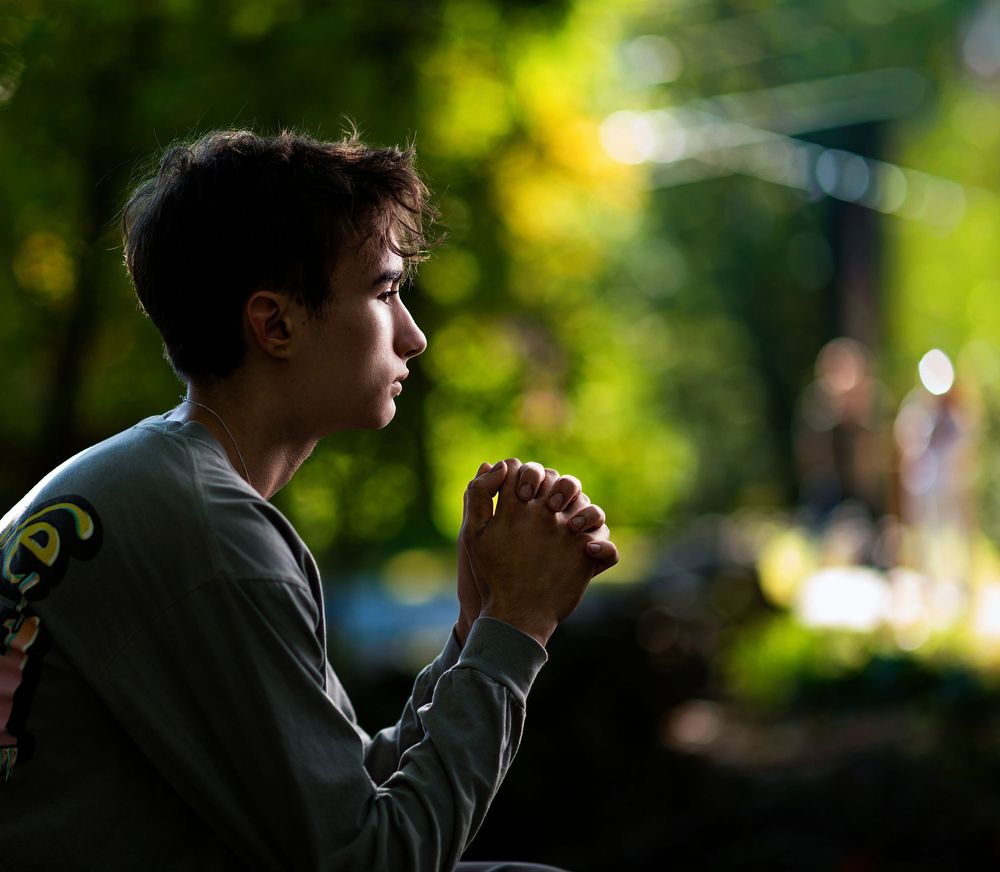 Dramatic silhouette portrait with natural backlit lighting outdoors.