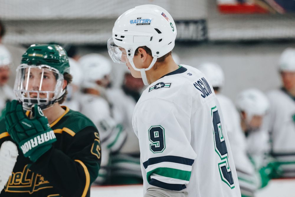 Ice hockey players from opposing teams face off during an intense game.