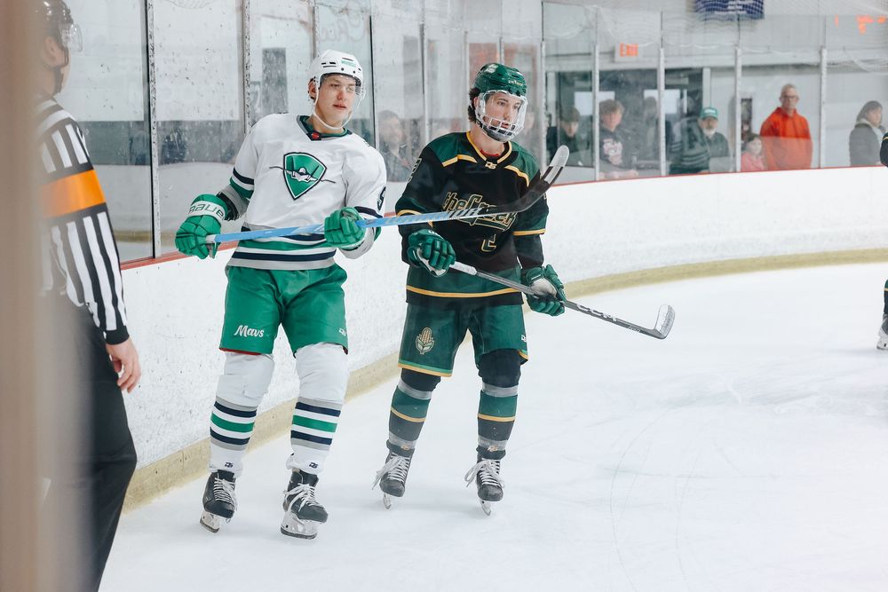 Hockey players in green and black jerseys compete for the puck during an intense ice hockey match.