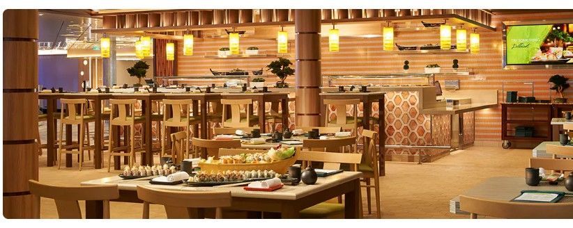 Interior view of an upscale restaurant dining room with warm lighting, wooden tables, and modern decor.