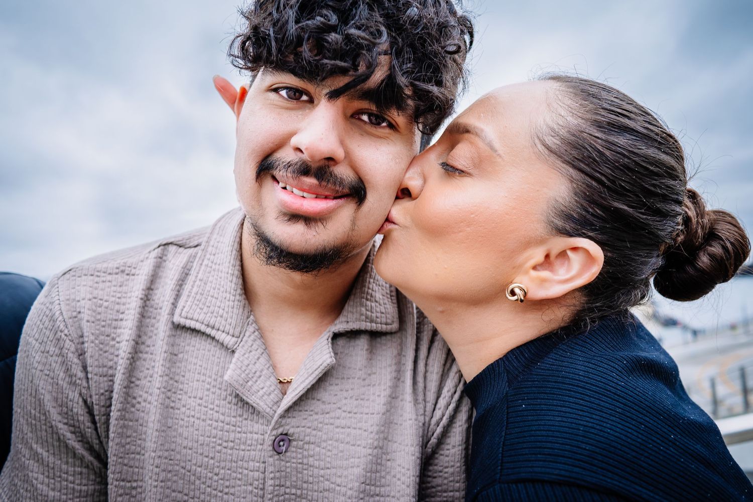 Mother kissing son during Seattle graduation photo session