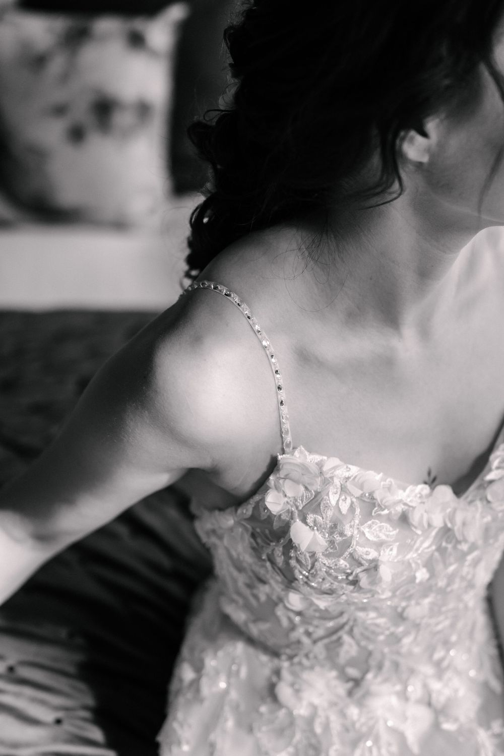 Black and white close-up photos showing details of a delicate lace wedding dress bodice with intricate beading.