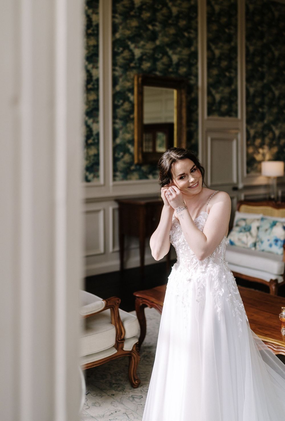 A sequence of photos showing a bride in a flowing white wedding dress getting ready in an elegant room.