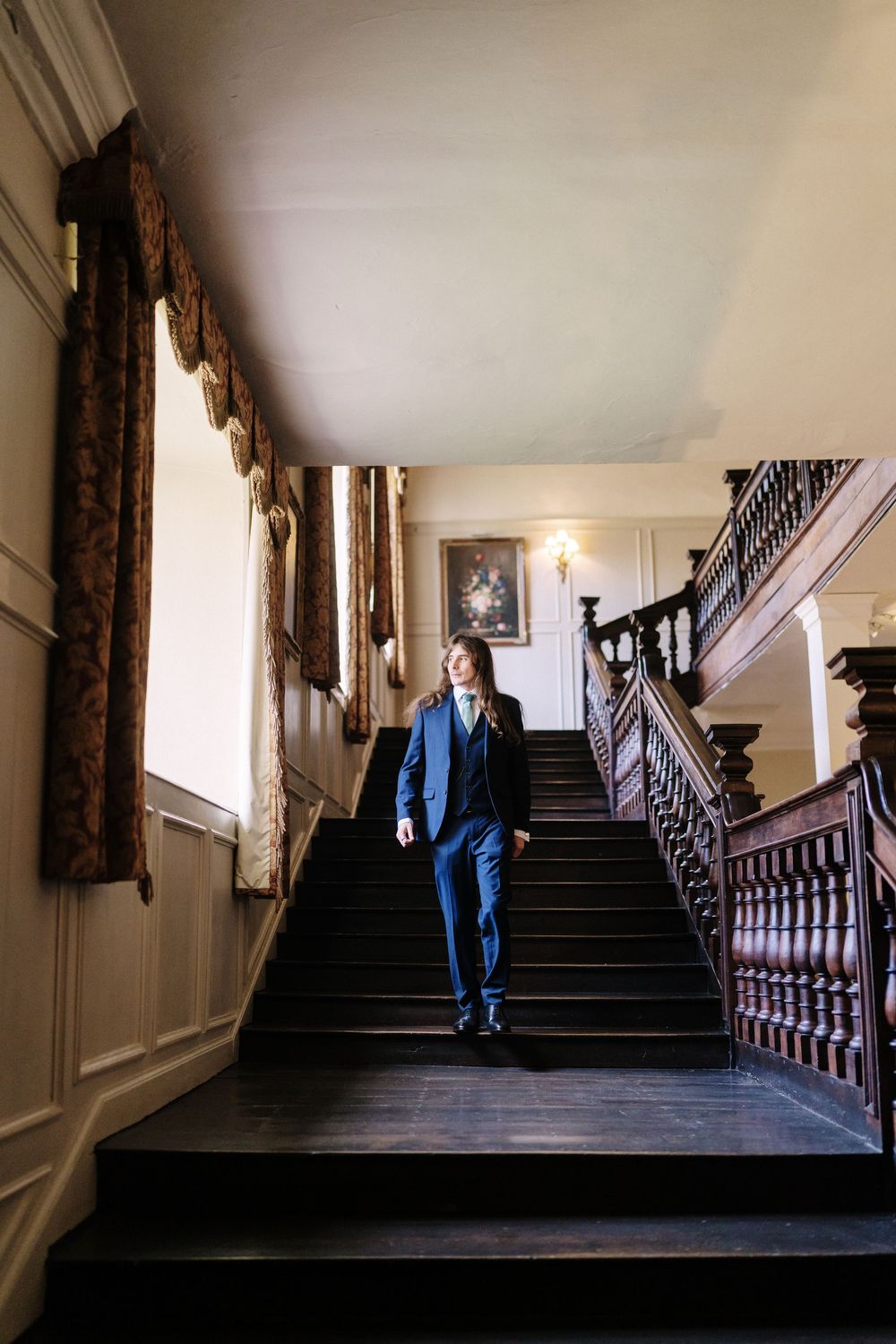 A series of moody photographs showing a dark staircase with ornate banisters in a historic building.