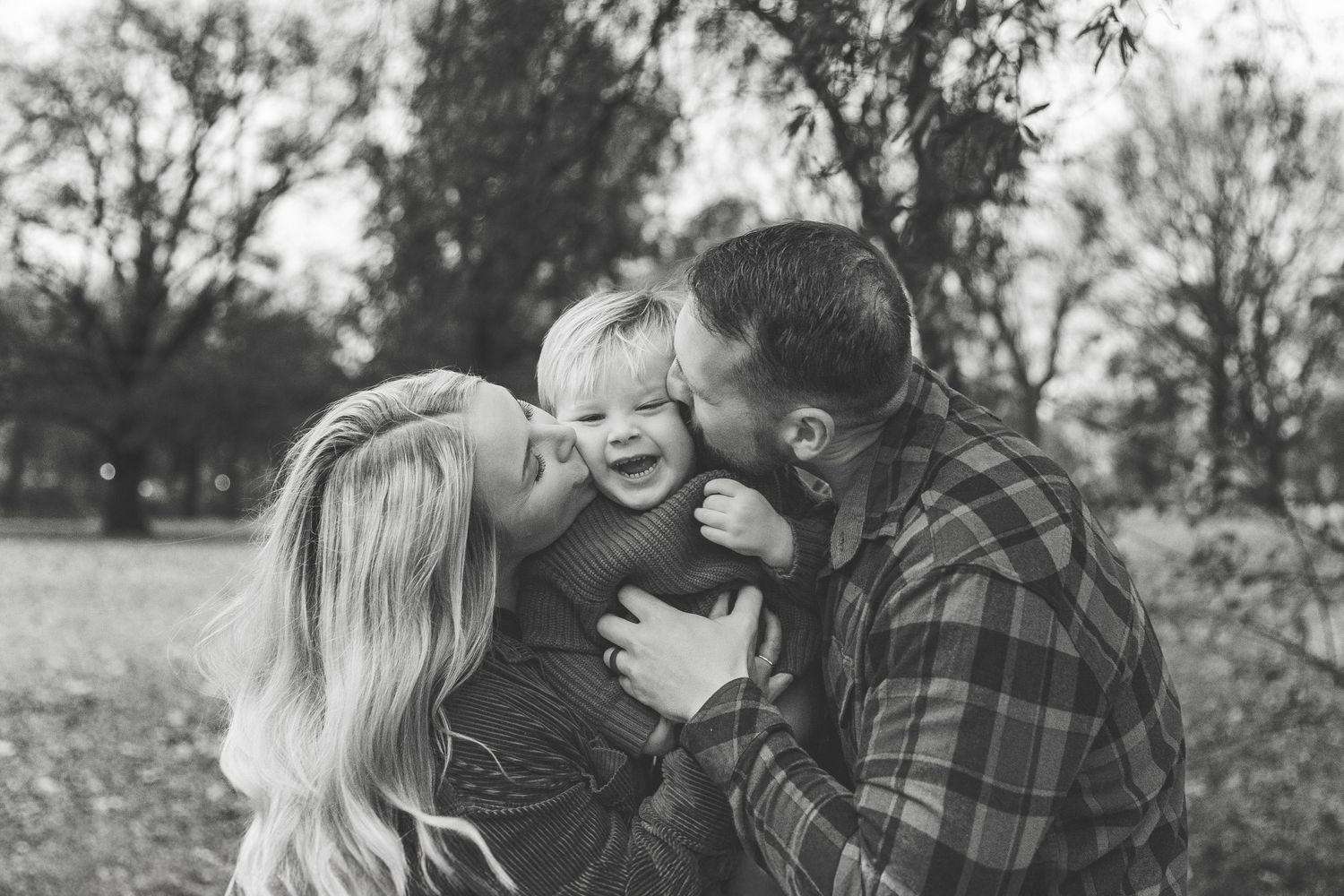 A couple shares tender moments in black and white photos during an outdoor engagement photo session.