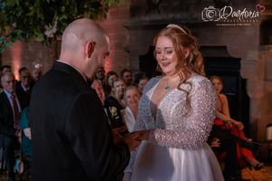 Joyful wedding celebration with couples dancing and enjoying a romantic evening reception in a rustic venue.