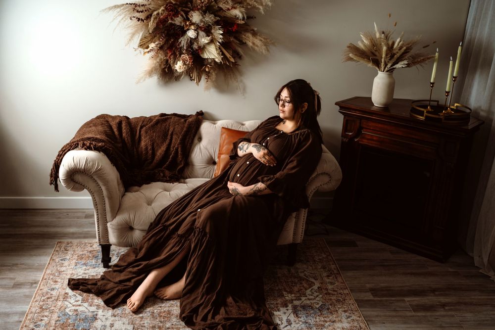 A figure in a flowing brown dress lies gracefully on a wooden floor in a series of artistic poses.