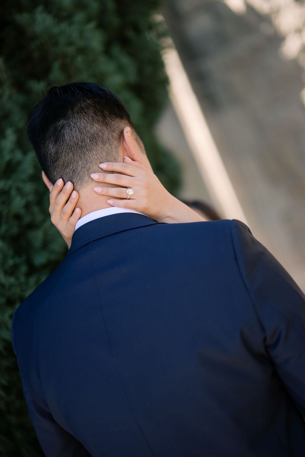 A series of close-up shots showing the back of someone's head in a navy suit jacket against a blurred background.