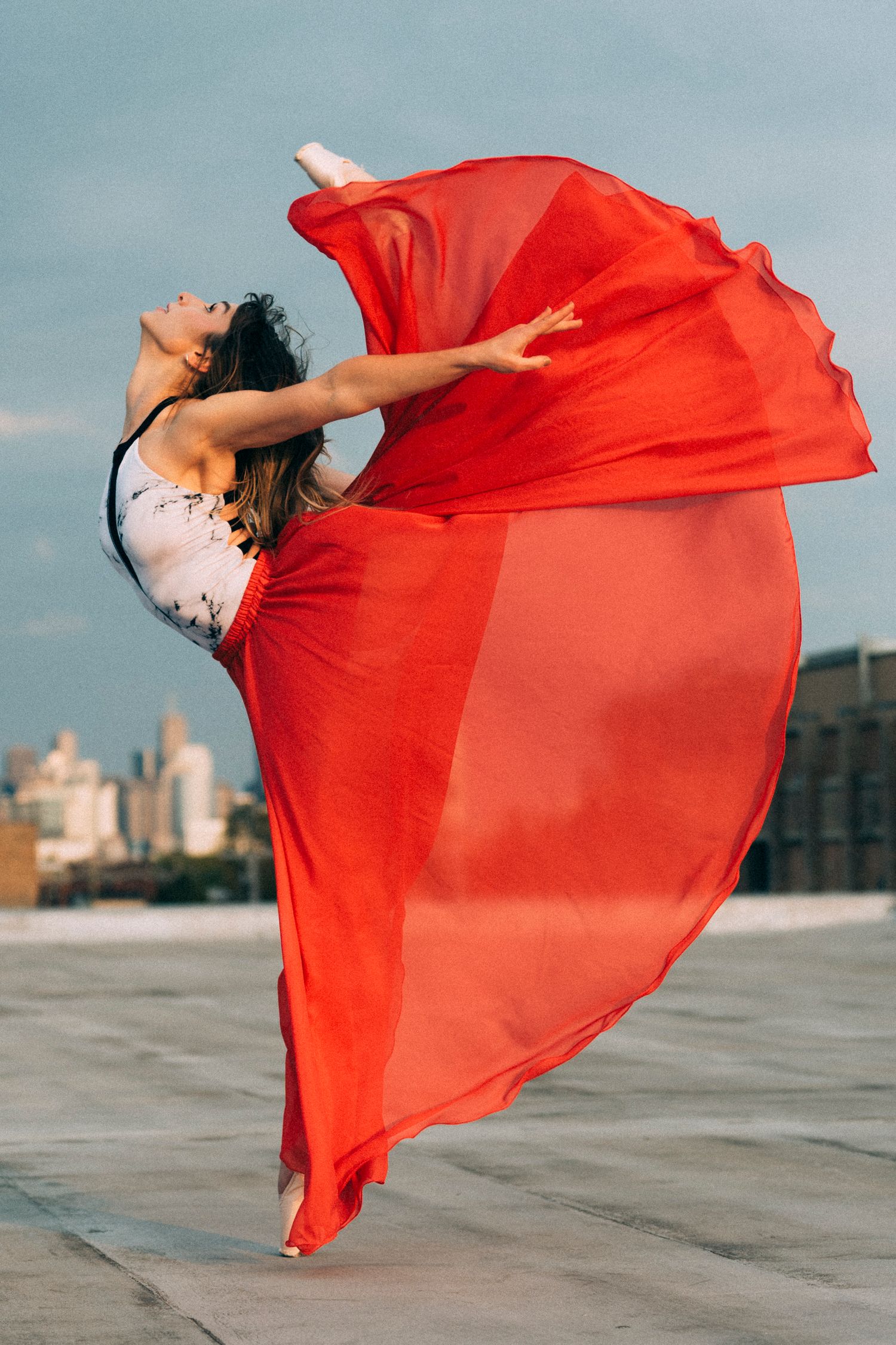 chicago dance photographer for ballet dancer.  Ballerina in leotard, pointe shoes and red skirt photographed on rooftop