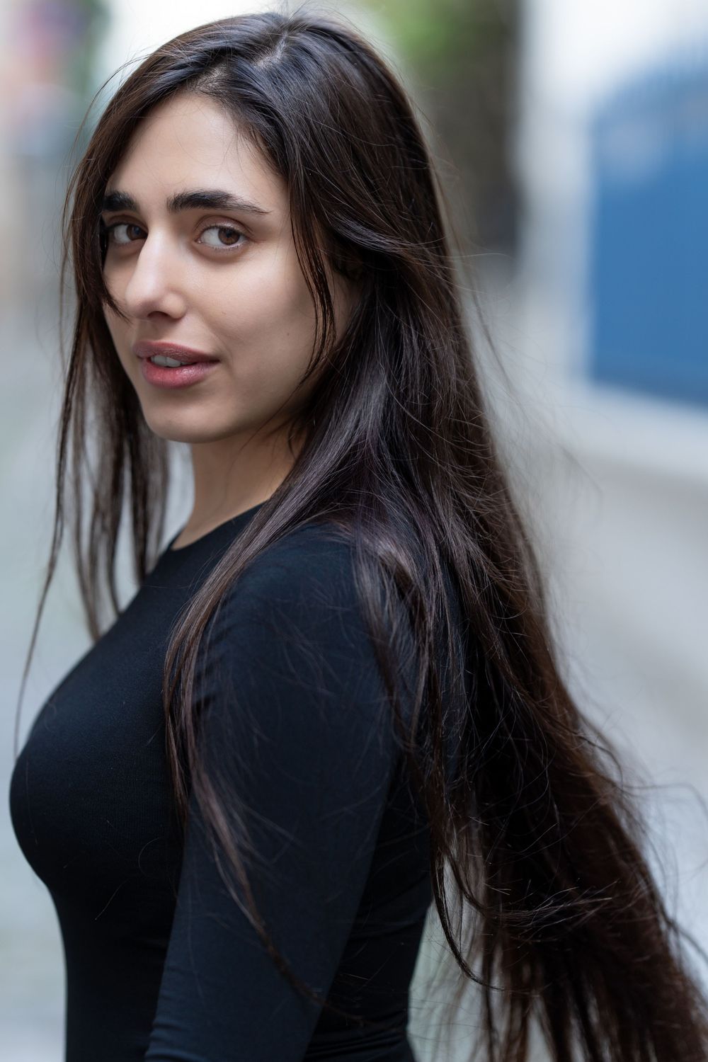 Outdoor fashion photography series featuring long dark hair and black top with natural lighting.