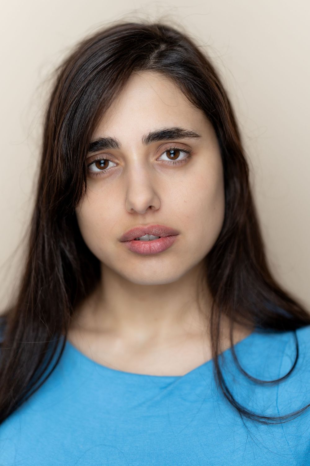 A series of six similar photos showing a person with long dark hair wearing a bright blue top against a light background.