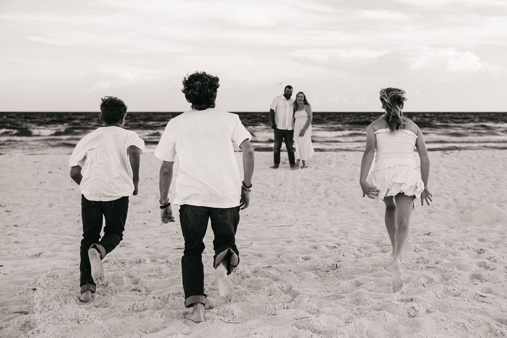 A collection of black and white photos showing people walking on a sandy beach against various ocean backdrops.