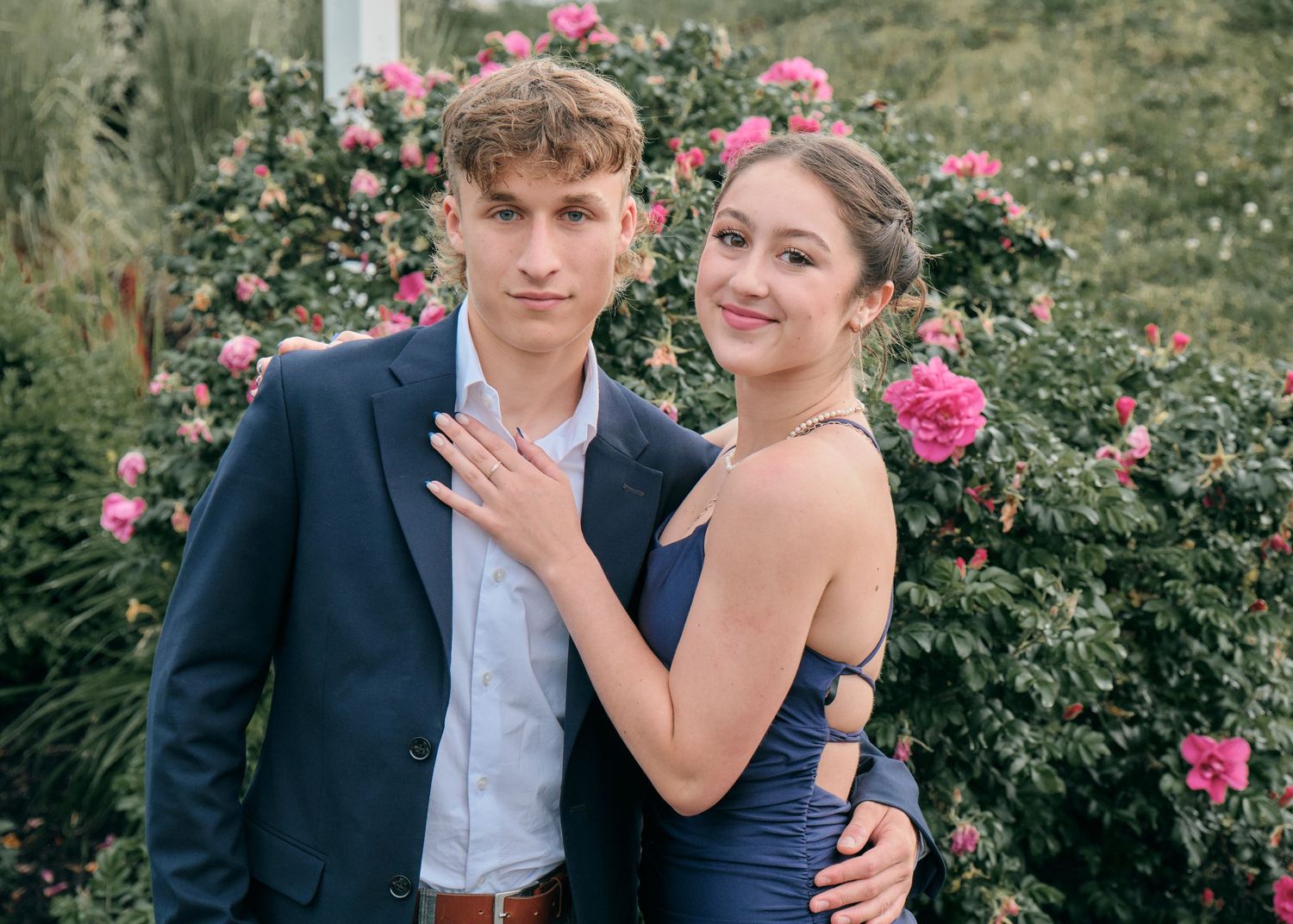 un couple en tenue de soirée devant un rosier en arrière-plan