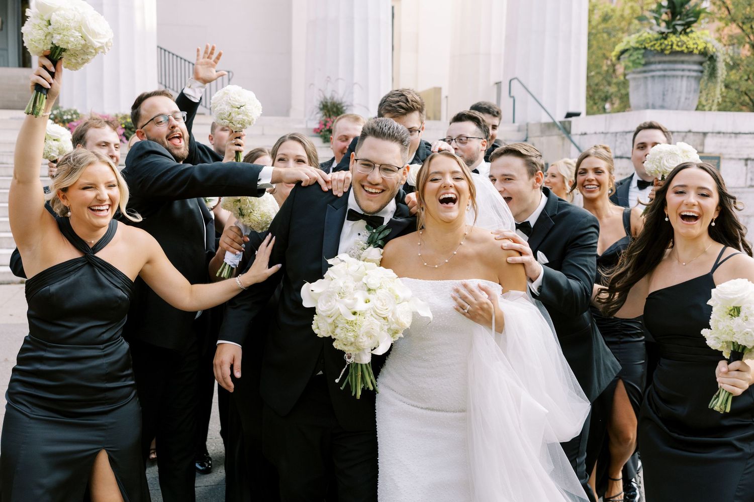 Wedding celebration group photos showing bridesmaids in black dresses and white bouquets embracing and posing together.