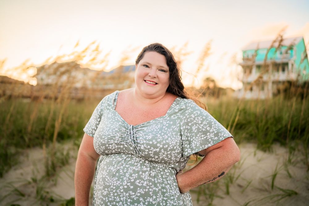 A beachside photo session in a floral dress shows someone posing against sand dunes at sunset.
