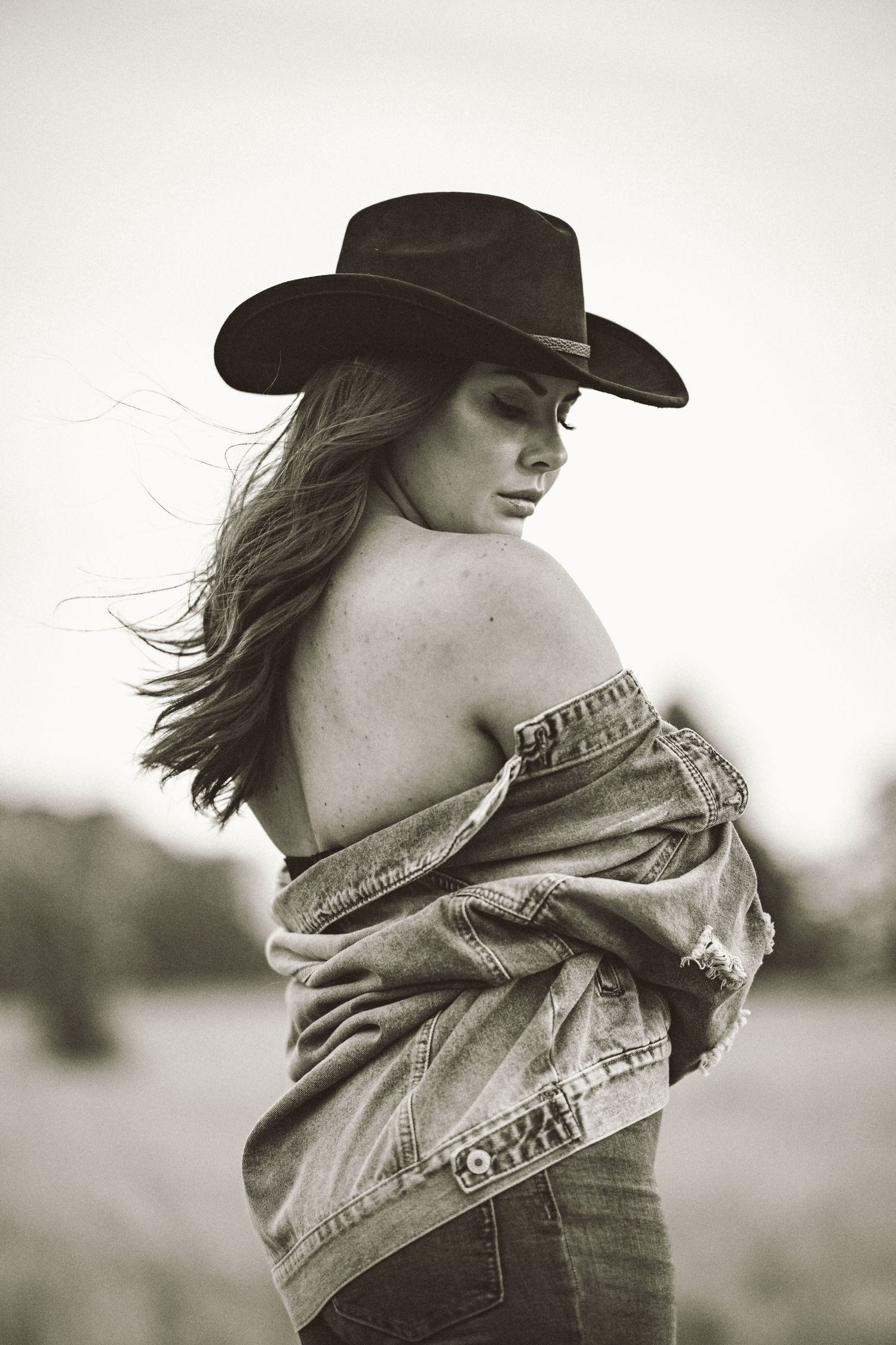 Cowgirl porträtt i svartvitt – kvinna i cowboyhatt och bustier med intensiv blick | Porträttfotograf Malmö