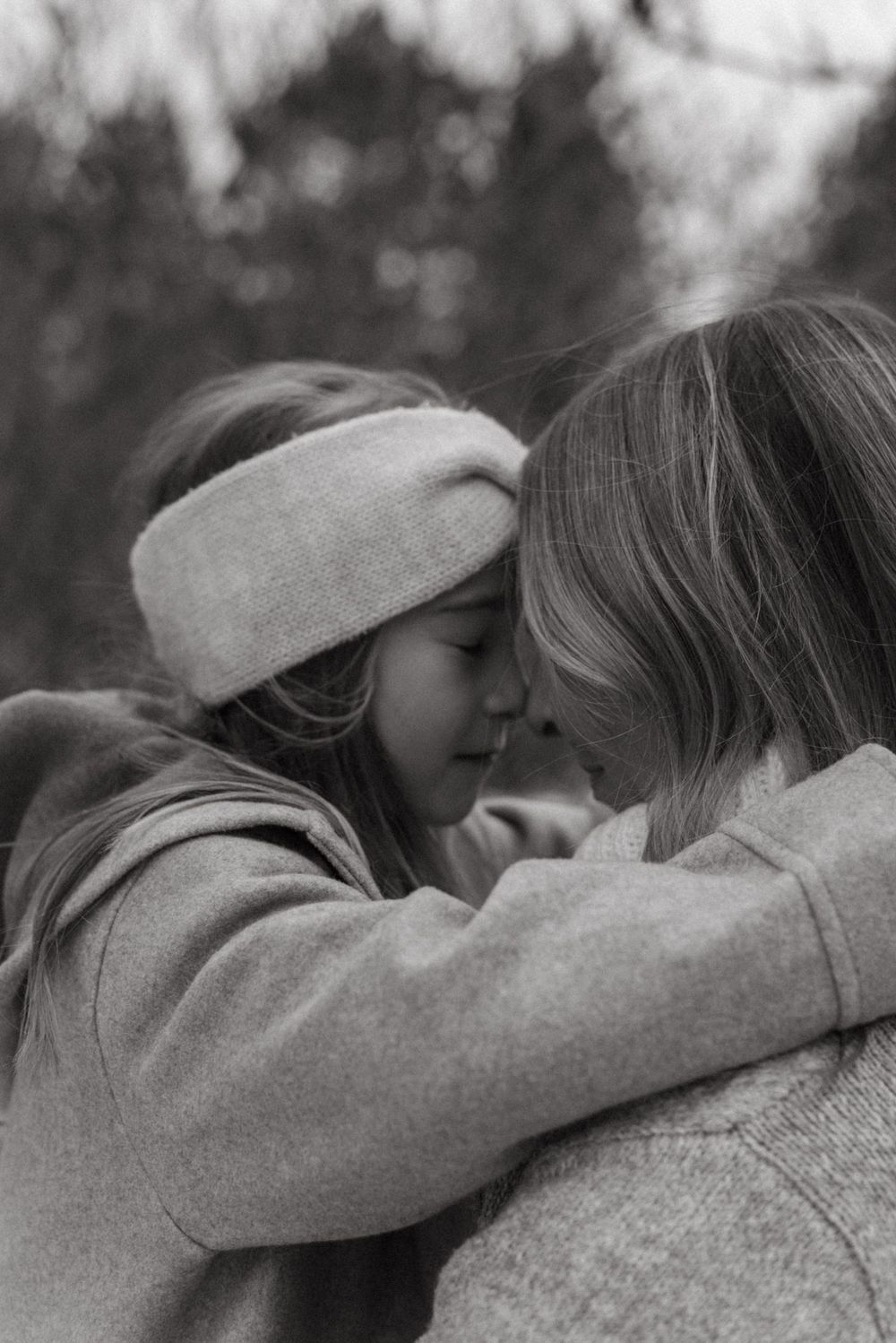 Two figures embrace tenderly in an intimate black and white outdoor portrait series.