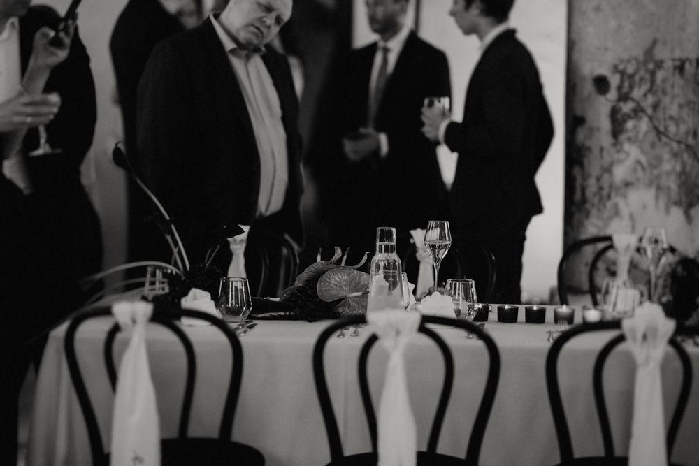 Wedding guests enjoying drinks and conversation at an elegant reception in a rustic venue.